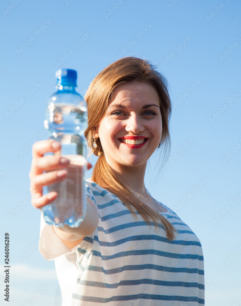 Happy young woman with a bottle of drinking water