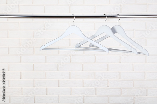Wooden hangers hanging on brick wall background