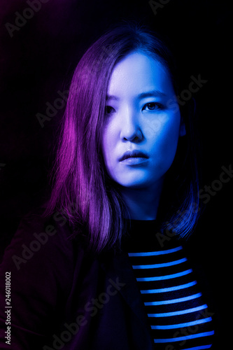 High Fashion model woman in colorful bright sparkles and neon lights posing in studio
