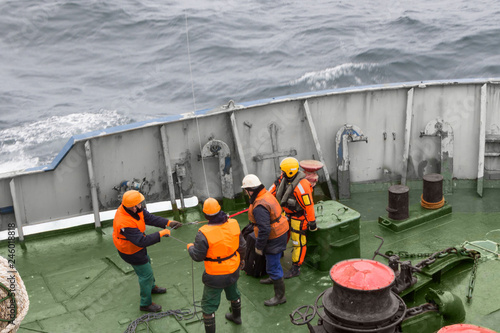 seamen carry out a rescue operation on the deck of a ship photo