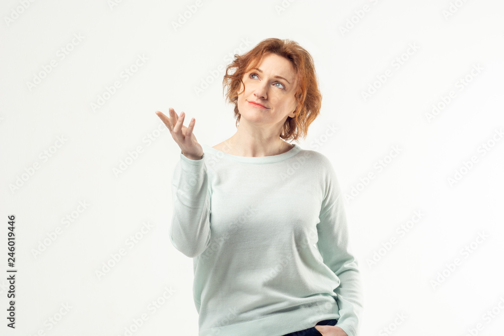 Fototapeta premium Elegant aged mature red haired woman looking up with dreamy and happy expression on her face and holding her right hand against white background
