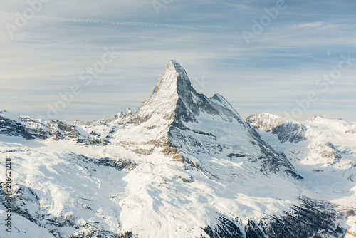 Scenic view on snowy Matterhorn peak in sunny day with cloudy sky in background  Switzerland