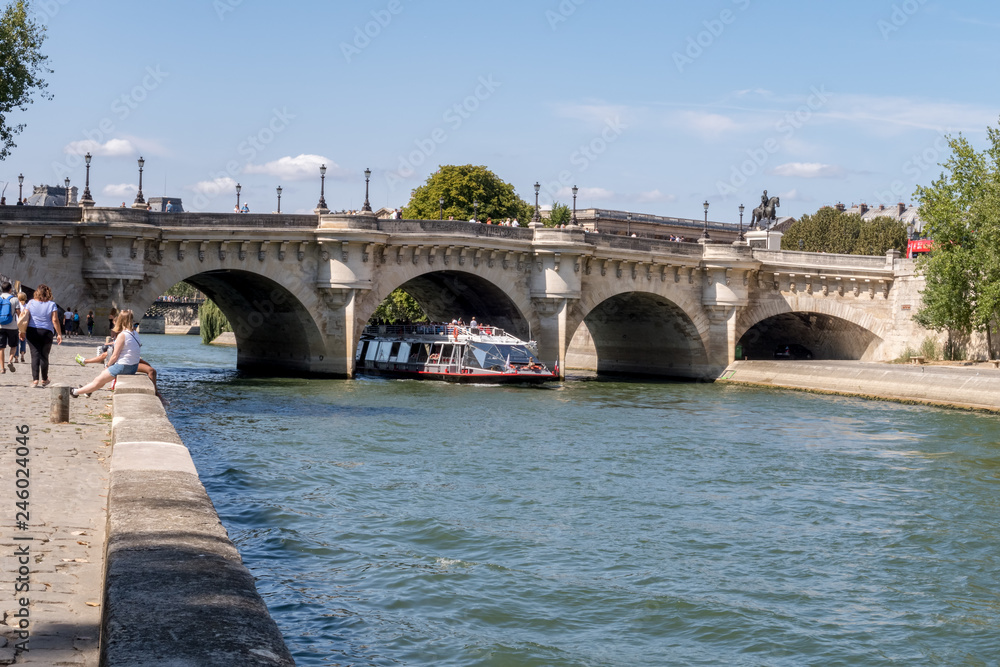 Boat traffic under the Pont Neuf - Paris, France. Pont Neuf is the oldest standing bridge across the river Seine.