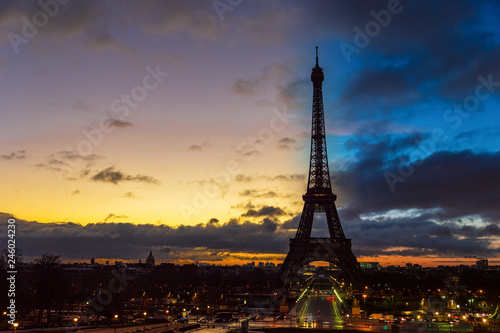 Sunrise over Paris roofs in winter with clouds and smoking chimneys - France