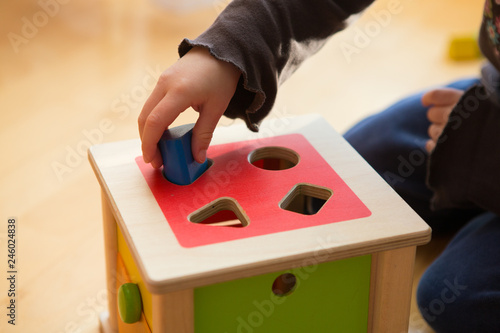 Kind spielt und lernt mit einem Motorikwürfel und passenden Bauklötzen