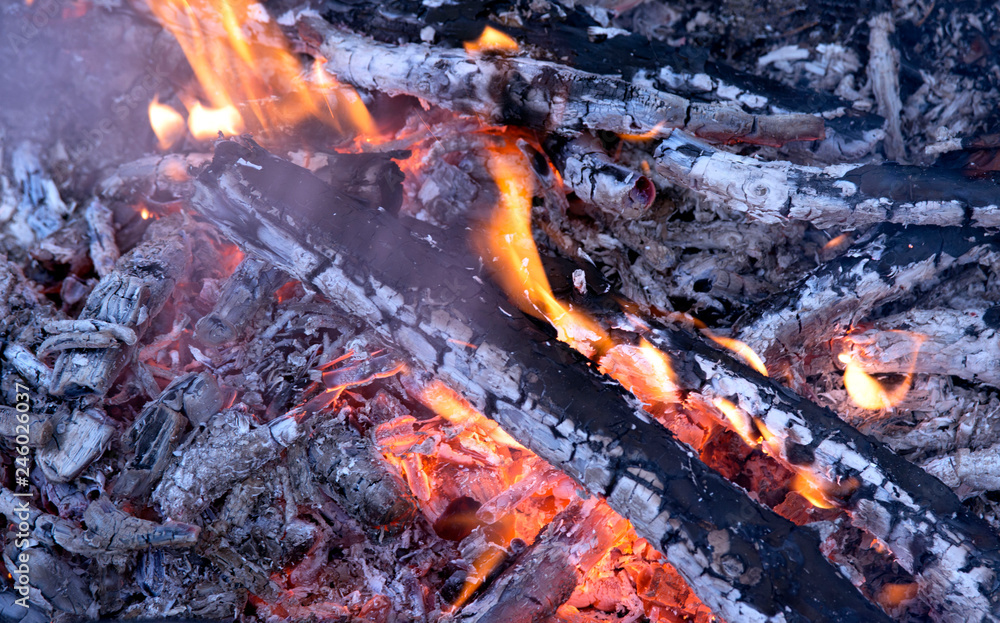 Hot coals and charred logs are engulfed in a fire. Near the fire so want to warm up on a frosty winter day with friends. Hot coals and charred logs are engulfed in a fire. Near the fire so want to warm up on a frosty winter day with friends.