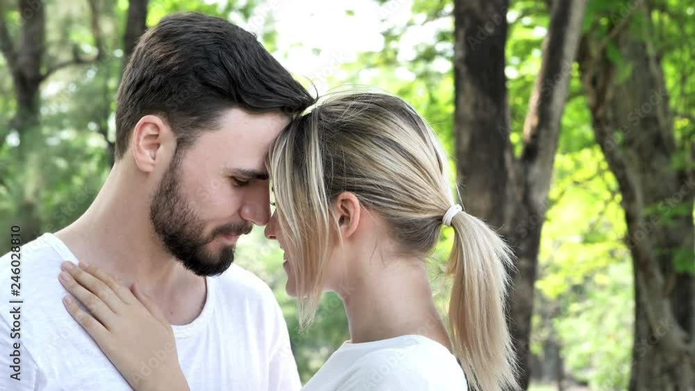 loving young couple kissing in a park on a sunny day. Valentine's day in nature. couple in love concept. Slow Motion loving young couple kissing in a park on a sunny day. Valentine's day in nature. couple in love concept. Slow Motion