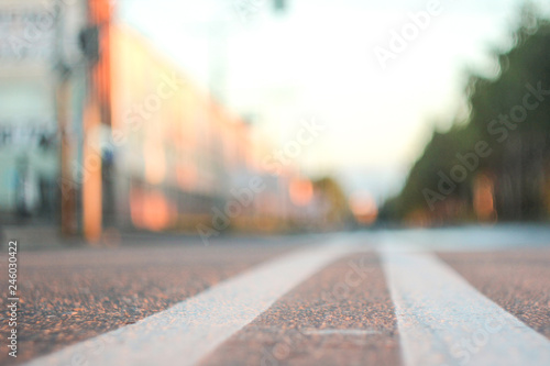 Photo of the road with a double solid strip with a small depth of field, blurred background and variable focus for wallpaper at sunrise