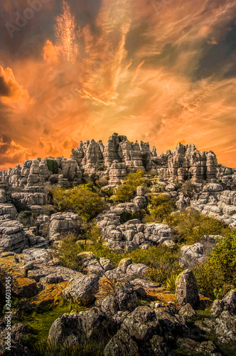 Prehistoric landscape in El Torcal de Antequera, Malaga, Spain. Views of the rock formations in a beautiful sunset with orange sky plenty of clouds. photo