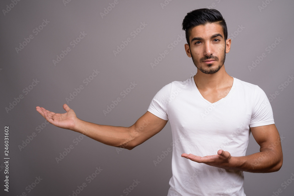 Young handsome Persian man against gray background Young handsome Persian man against gray background
