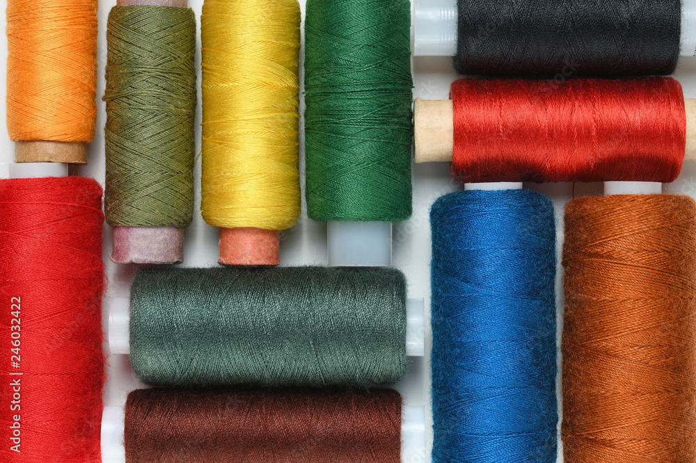 Colorful spools of thread close-up on white table Colorful spools of thread close-up on white table