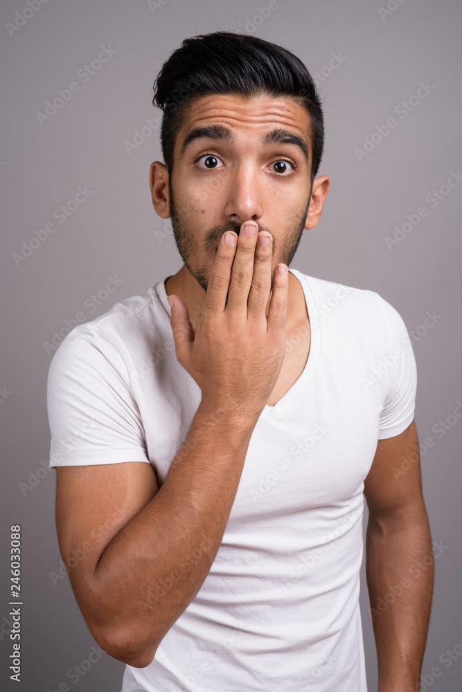 Young handsome Persian man against gray background Young handsome Persian man against gray background
