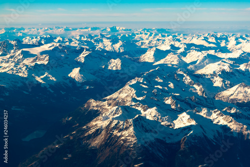 Swiss, Italy and Austrian Alps with snowy mountain tops aerial view towards the east during afternoon flight