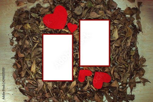 Red hearth on dread leaves and white paper, copy space