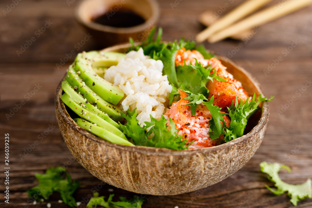 Hawaiian poke coconut bowl with grilled salmon fish, rice and avocado ...