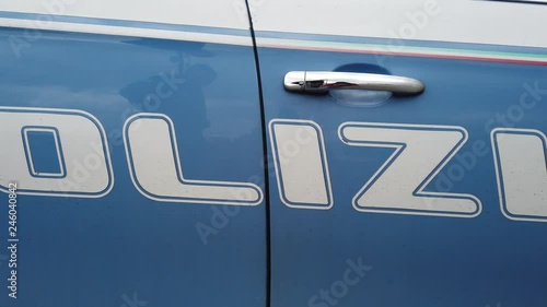 Slow overview of the white writing Italian police on the profile of the service blue car