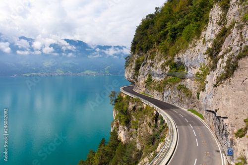 A curved road built into the side of a mountain next to Lake Thun, Interlaken, Bernese Oberland, Bern photo