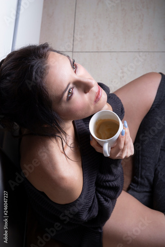 Mujer pensativa tomando café