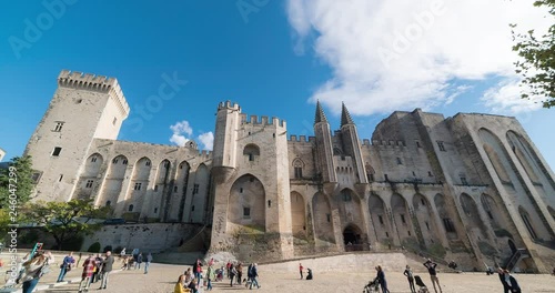 time lapse of papal palace (Palais des papes) under clear blue sky in Avignon, France. Unidentified tourist passing by. 4k footage