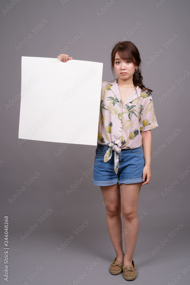Asian woman holding empty white board with copyspace Asian woman holding empty white board with copyspace