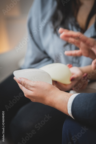 Plastic surgeon and patient discuss choice of breast implants after mastectomy or for breast augmentation. 
