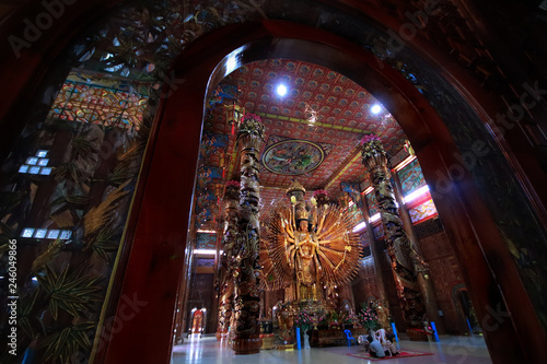 Take photo man and woman with large Guan Yin Bodhisattva carved from wood 12 meters high in Wat Metta Photiyan photo