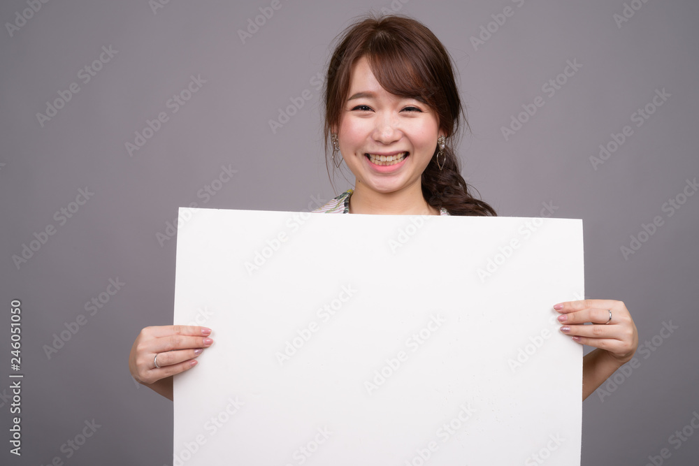 Asian woman holding empty white board with copyspace Asian woman holding empty white board with copyspace