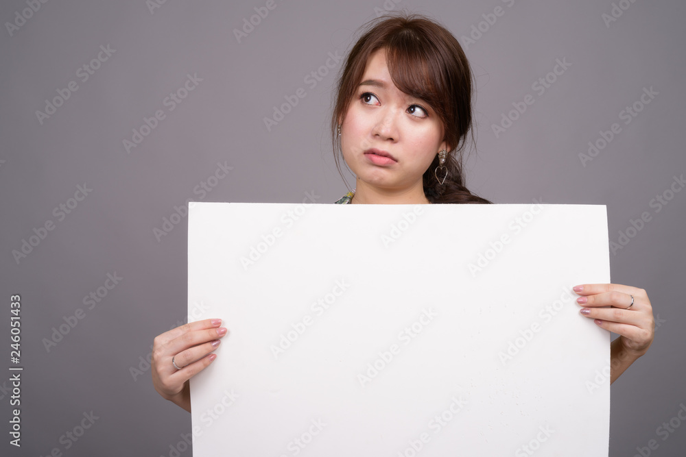Asian woman holding empty white board with copyspace Asian woman holding empty white board with copyspace