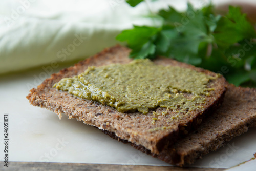 Whole grain bread with fresh basil pesto. close up. Healthy food snack.