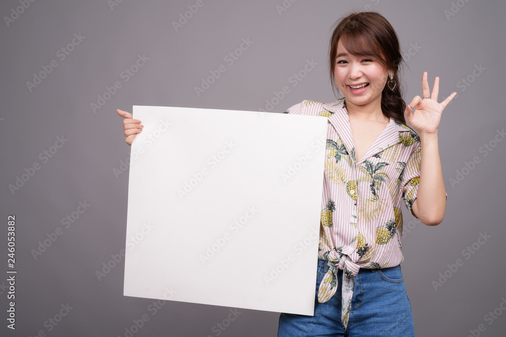 Asian woman holding empty white board with copyspace Asian woman holding empty white board with copyspace