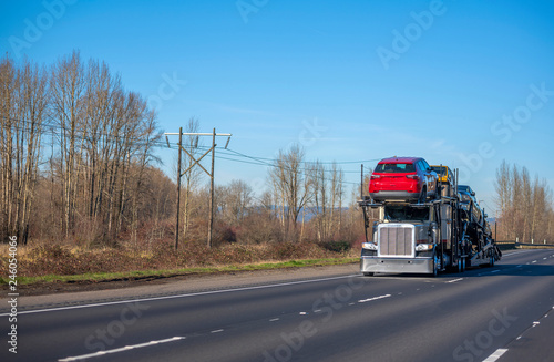 Canvas Print Big rig car hauler semi truck transporting cars on semi trailer and driving on a