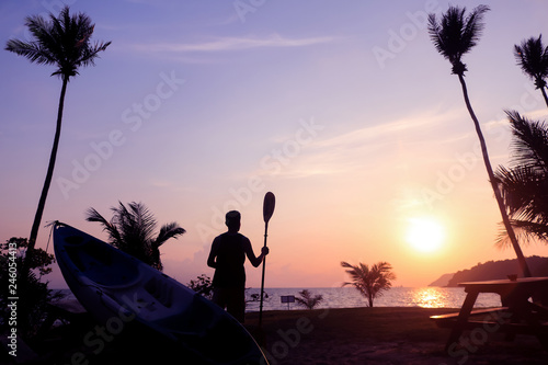 Local people hold the paddle with kayak on the beach at sunrise