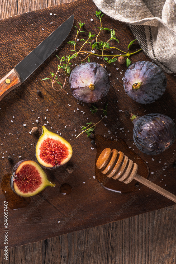 Fresh figs. Whole figs and sliced in half figs on wooden cutting board.