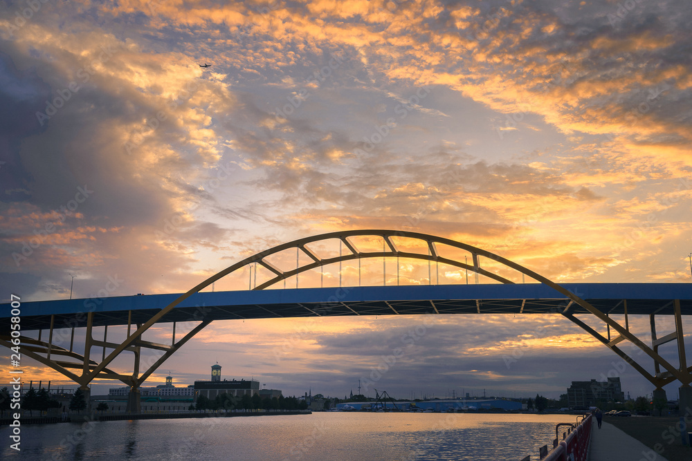Naklejka premium Sailboat going under Hoan Bridge in Milwaukee, Wisconsin at Sunset