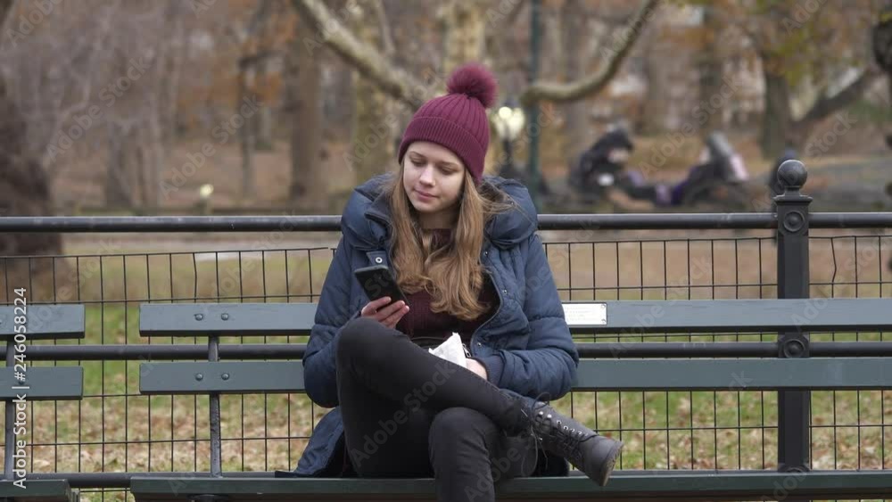 Young woman sits on a bench in Central Park New York Young woman sits on a bench in Central Park New York