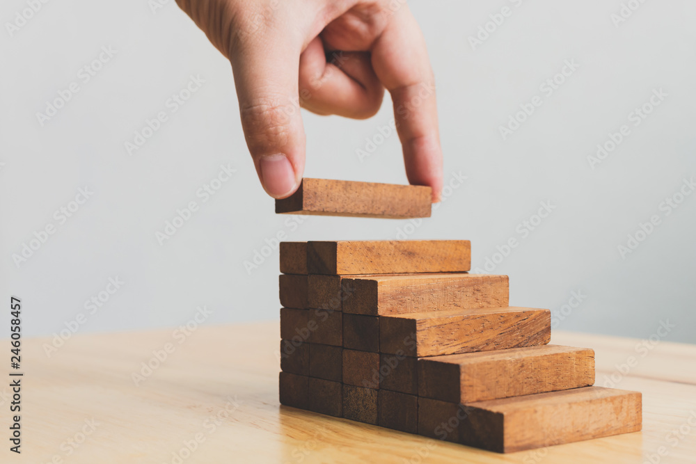 Hand arranging wood block stacking as step stair. Ladder career path concept for business growth success process Hand arranging wood block stacking as step stair. Ladder career path concept for business growth success process