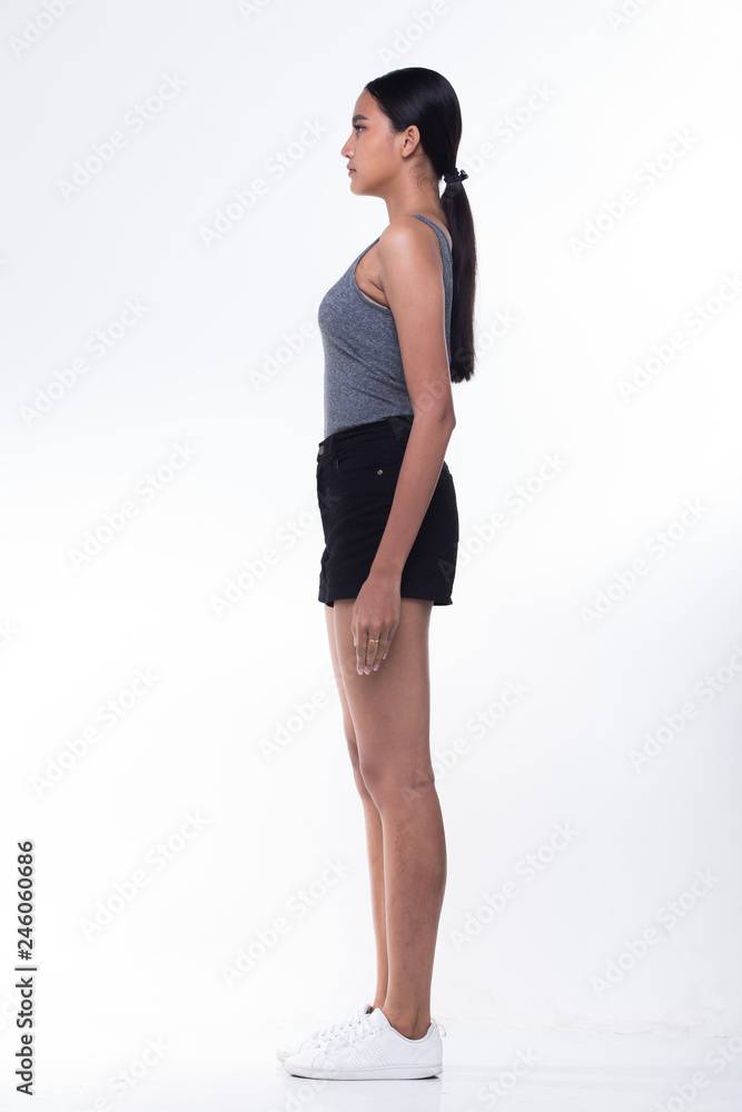 Fototapeta premium Piękne azjatyckie długie proste czarne włosy opalona skóra kobieta w szarej ogromnej, szczupłej, czarnej, krótkiej białej butach, bez makijażu świeżej twarzy, oświetlenie studyjne białe tło na białym tle miejsce na kopię, przystawka na całej długości