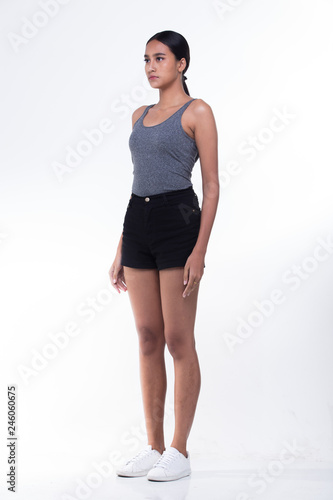 Beautiful Asian Long straight black hair tan skin woman in gray vast slim black short white shoes, no make up fresh face, studio lighting white background isolated copy space, full length snap