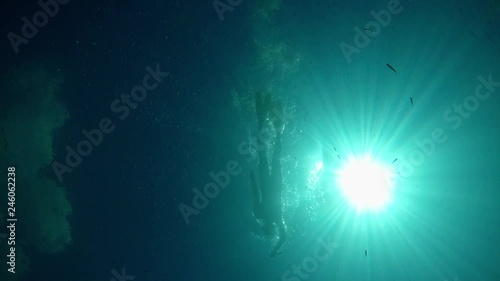 Man in flippers swimming  crawl on the surface of Lake Ohrid in Macedonia in very clear and transparent water. Shot from bottom. photo