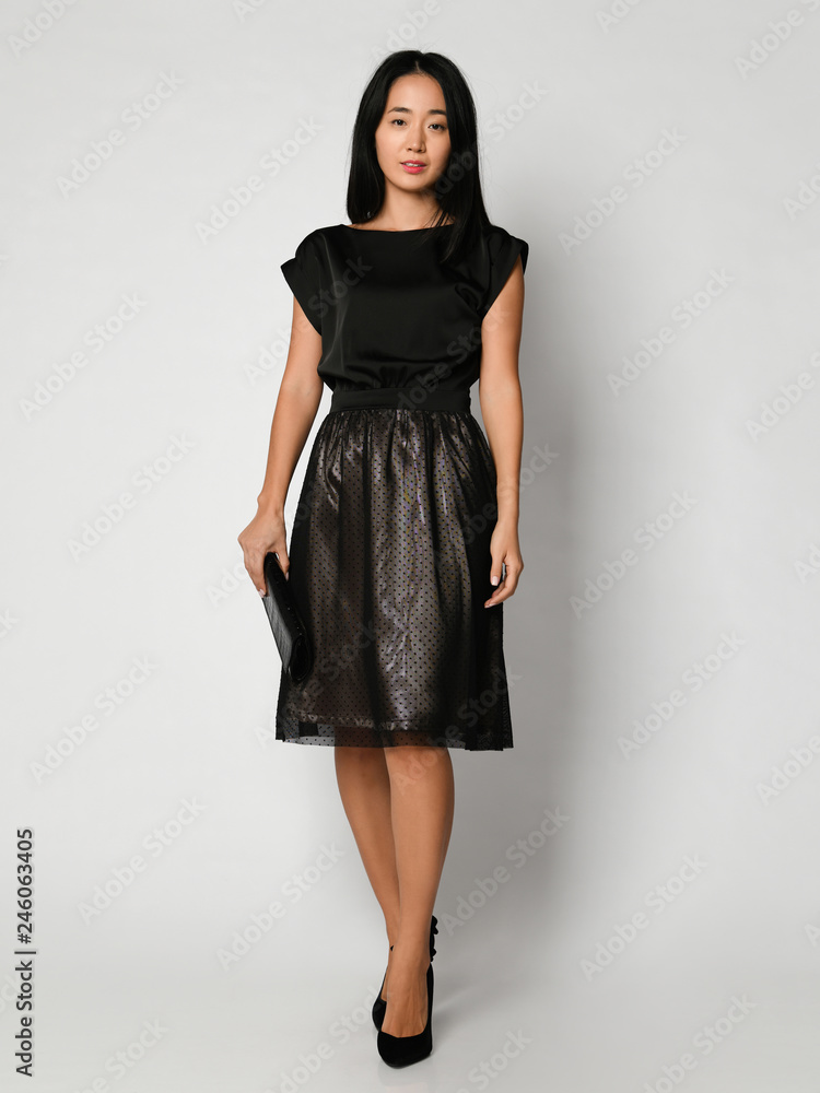 Young beautiful asian woman posing in new black fashion winter dress full body on a white Young beautiful asian woman posing in new black fashion winter dress full body on a white