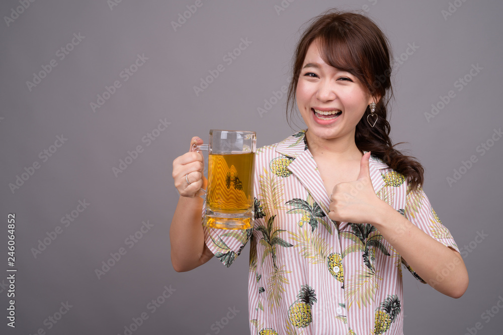 Young beautiful Asian tourist woman holding glass of beer Young beautiful Asian tourist woman holding glass of beer