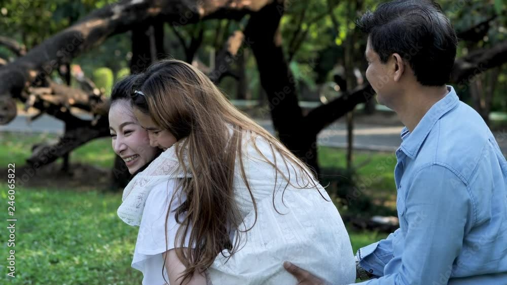 Happy Asian family, father, mother and daughter Having fun enjoying activity playing with children in a park on a sunny day. healthy life, lifestyle concept. Slow Motion Happy Asian family, father, mother and daughter Having fun enjoying activity playing with children in a park on a sunny day. healthy life, lifestyle concept. Slow Motion