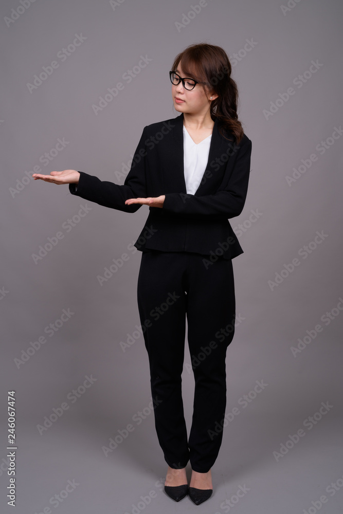 Full length portrait of young Asian businesswoman standing Full length portrait of young Asian businesswoman standing