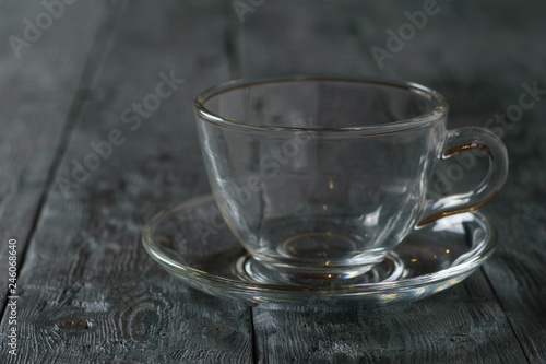 Empty glass Cup with saucer on wooden rustic wooden table.