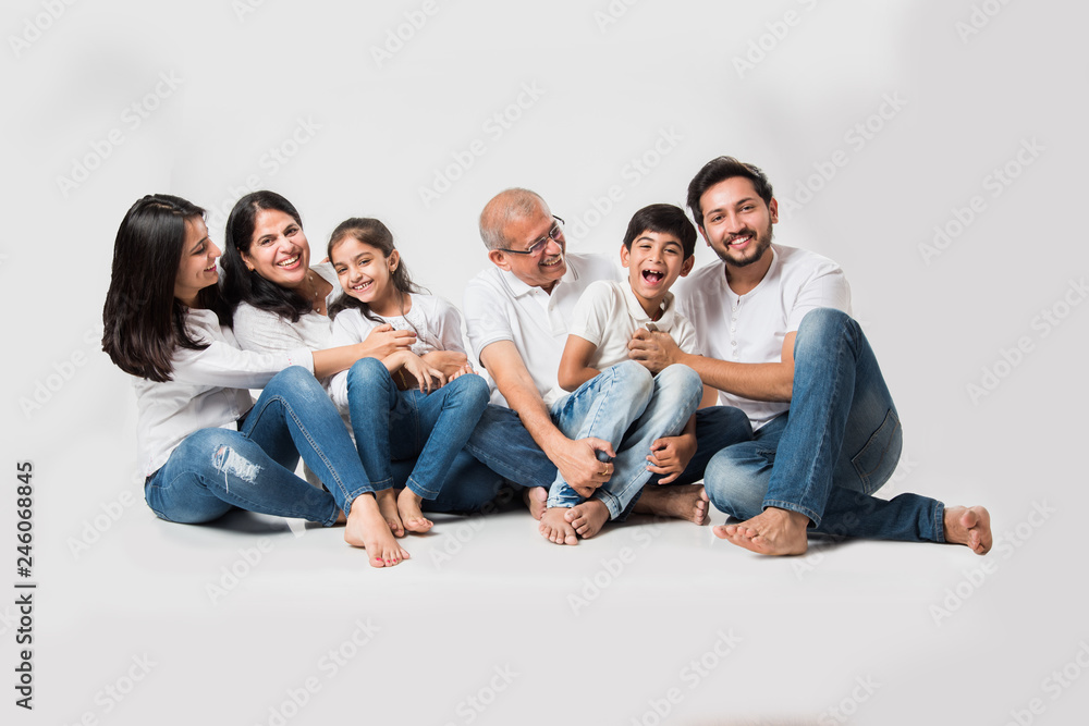 indian/asian family sitting over white background. senior and young couple  with kids wearing white top and blue jeans. selective focus Stock Photo |  Adobe Stock