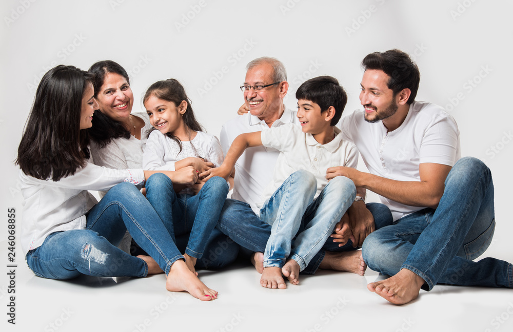 indian/asian family sitting over white background. senior and young couple  with kids wearing white top and blue jeans. selective focus Stock Photo |  Adobe Stock
