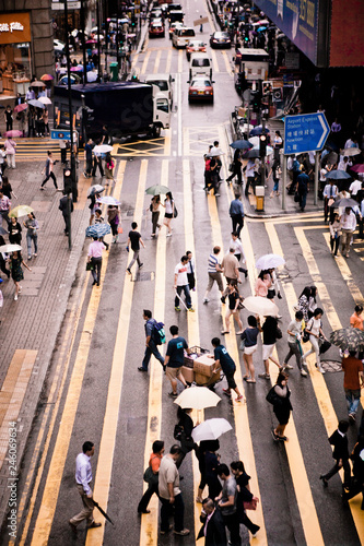 Streams of people with umbrellas cross the street in Central Hong Kong. photo