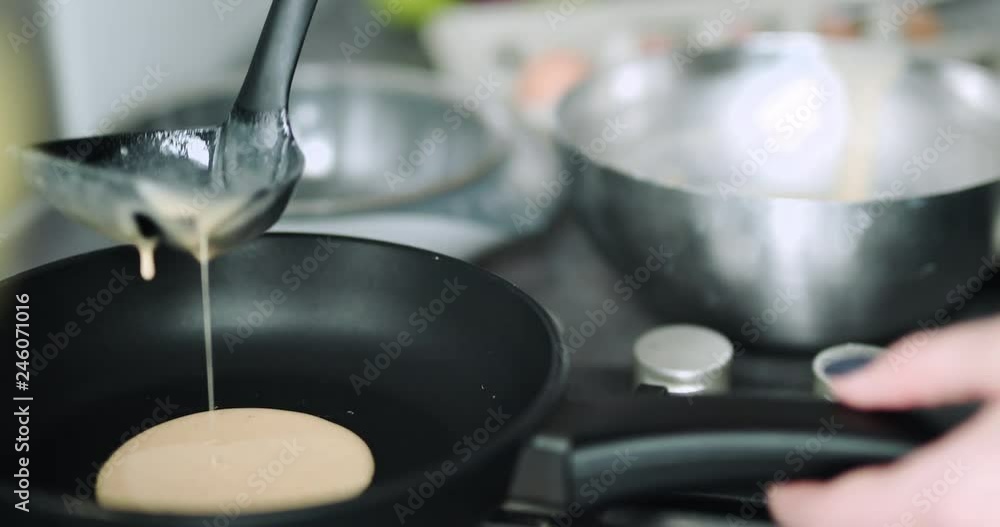 Girl cooking pancakes in the kitchen, home with flowers, eggs, fruits on the table. Girl cooking pancakes in the kitchen, home with flowers, eggs, fruits on the table.