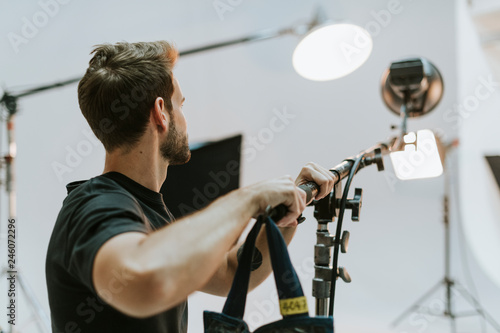 Young man adjusting the light in a studio