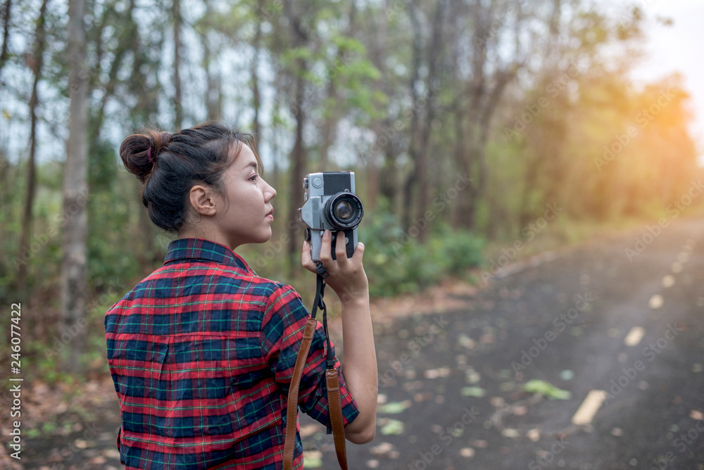 Beautiful woman with retro camera on the street in the forest alone.
Beautiful woman with retro camera on the street in the forest alone.